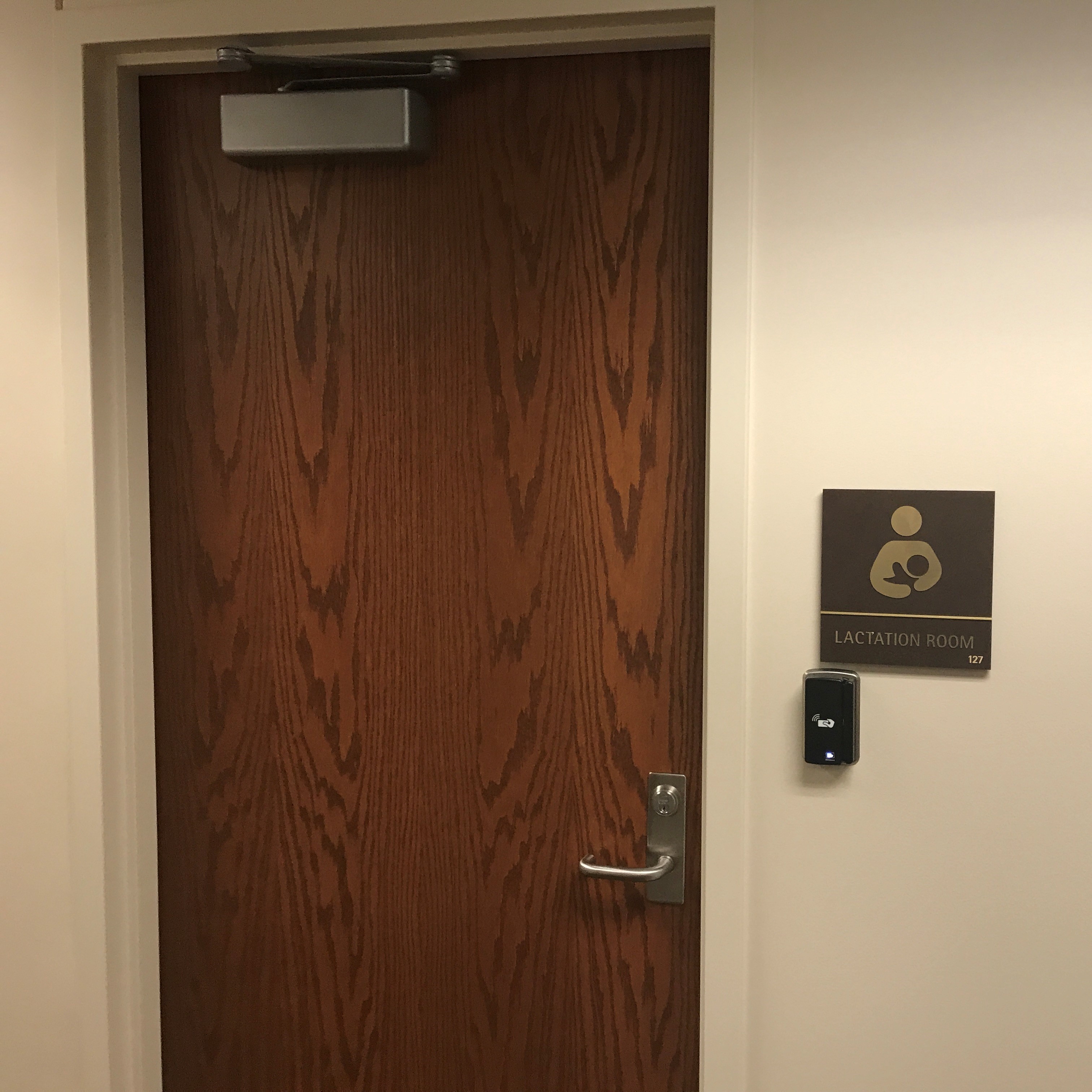 A door with a lock. There is a card swipe to the right of the door, and above that is a plaque that says, "Lactation Room 127"